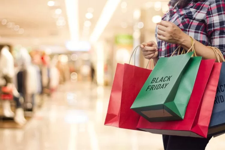 black friday woman holding many shopping bags while walking in the shopping mall min scaled